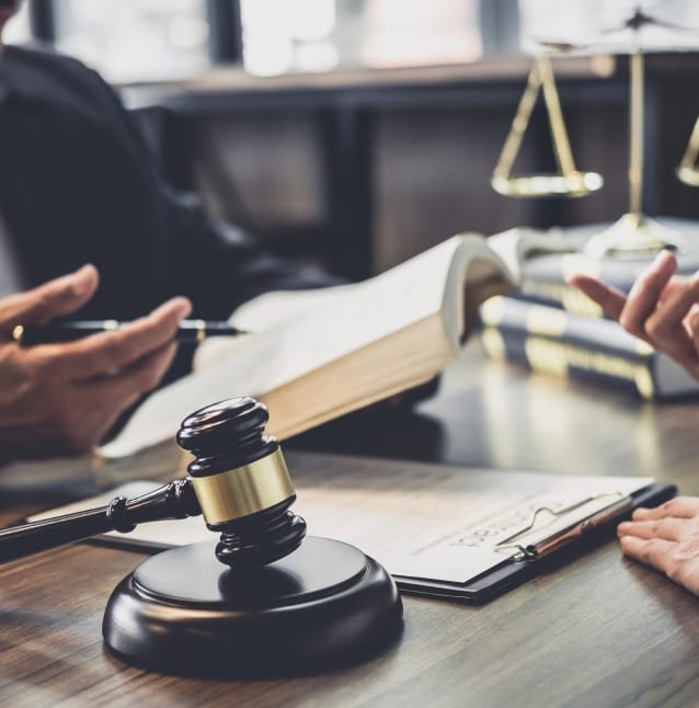 A lawyer's desk with a judge's gavel, an open book and the scales of justice